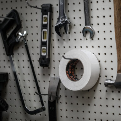 White T-Rex roll of tape on a pegboard with tools